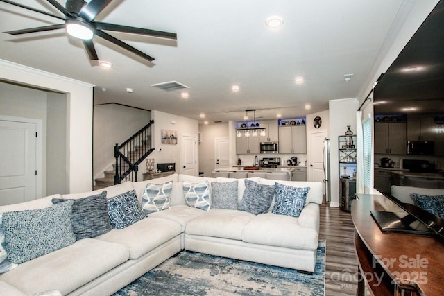 11951 Old Statesville Rd, Huntersville, NC 28078 - living room featuring a ceiling fan, dark wood-type flooring, recessed lighting, stairs, and crown molding