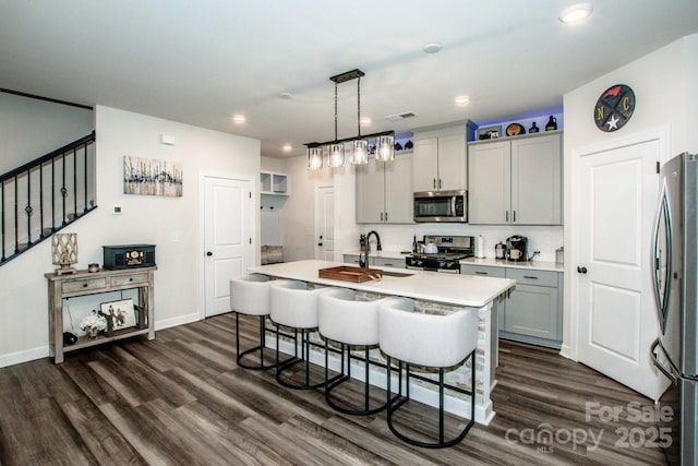 11951 Old Statesville Rd, Huntersville, NC 28078 - kitchen with appliances with stainless steel finishes, a sink, a breakfast bar, light countertops, and dark wood finished floors