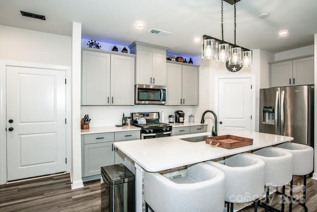 11951 Old Statesville Rd, Huntersville, NC 28078 - kitchen featuring stainless steel appliances, a sink, a kitchen breakfast bar, dark wood-style flooring, and recessed lighting