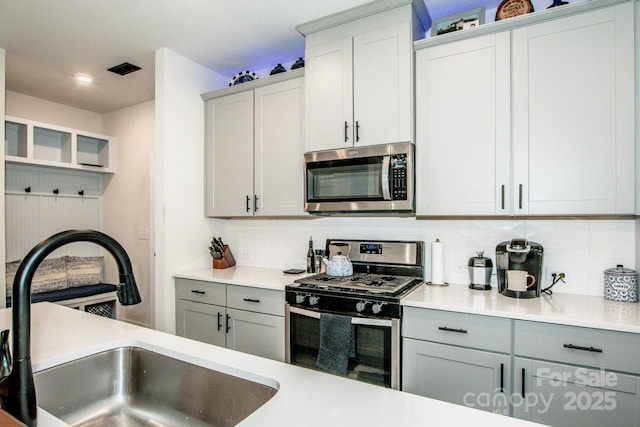 11951 Old Statesville Rd, Huntersville, NC 28078 - kitchen featuring appliances with stainless steel finishes, a sink, gray cabinets, decorative backsplash, and recessed lighting