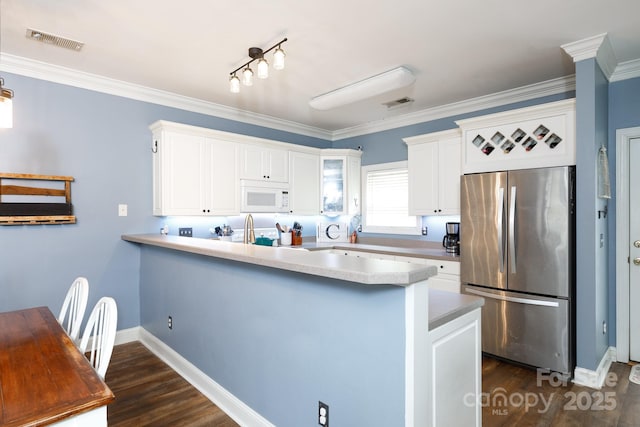 556 Knighton Hill Rd, Rock Hill, SC 29732 - kitchen with freestanding refrigerator, white microwave, a peninsula, white cabinets, and crown molding