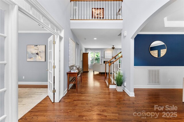 6300 Latta Springs Cir, Huntersville, NC 28078 - entryway featuring wood finished floors, stairs, a ceiling fan, arched walkways, and crown molding
