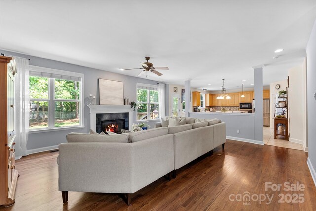 6300 Latta Springs Cir, Huntersville, NC 28078 - living area featuring a glass covered fireplace, a ceiling fan, baseboards, wood finished floors, and recessed lighting
