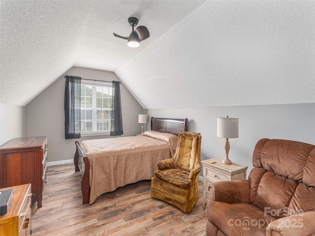 379 Running Briar Rd, Fletcher, NC 28732 - bedroom featuring a textured ceiling, wood finished floors, vaulted ceiling, ceiling fan, and baseboards