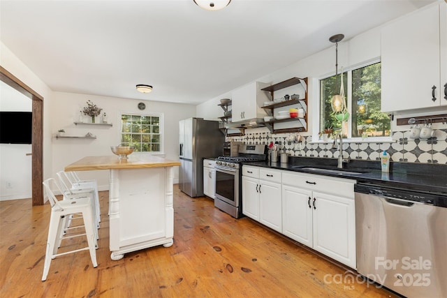 7015 Lavern St, Charlotte, NC 28215 - kitchen with appliances with stainless steel finishes, open shelves, white cabinets, backsplash, and decorative light fixtures