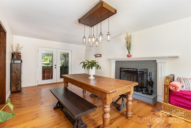 7015 Lavern St, Charlotte, NC 28215 - dining room featuring light wood finished floors, a fireplace, and french doors