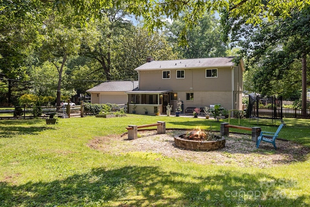 7015 Lavern St, Charlotte, NC 28215 - rear view of property featuring a fire pit, an attached garage, a sunroom, a chimney, and view of wooded area