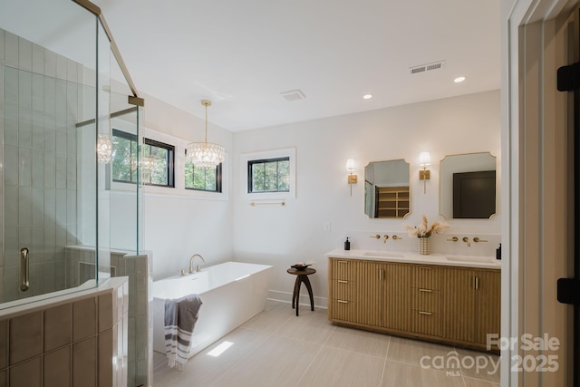 1625 Club Rd, Charlotte, NC 28205 - bathroom with a freestanding bath, double vanity, a shower stall, a chandelier, and tile patterned floors