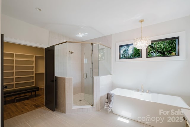 1625 Club Rd, Charlotte, NC 28205 - full bath featuring a freestanding tub, tile patterned floors, a shower stall, a chandelier, and a walk in closet