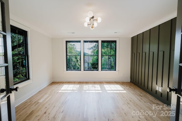 1625 Club Rd, Charlotte, NC 28205 - unfurnished room featuring healthy amount of natural light, a chandelier, light wood-type flooring, and ornamental molding