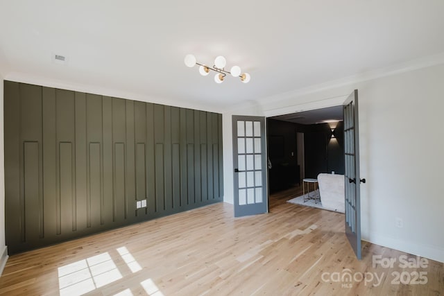1625 Club Rd, Charlotte, NC 28205 - unfurnished bedroom featuring light wood-style flooring, a chandelier, crown molding, and french doors