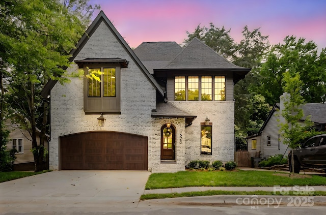 1625 Club Rd, Charlotte, NC 28205 - french country home featuring a garage, brick siding, driveway, and roof with shingles