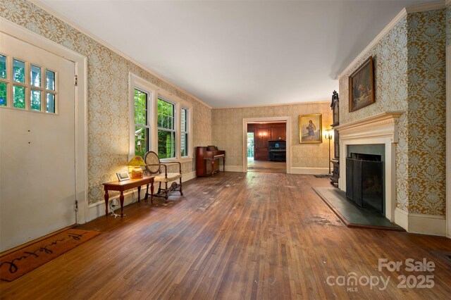 93 Villa Barbara Ln, Tryon, NC 28782 - living room with hardwood / wood-style floors, wallpapered walls, a fireplace with raised hearth, and ornamental molding