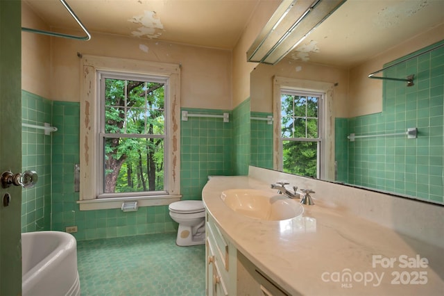 93 Villa Barbara Ln, Tryon, NC 28782 - bathroom with tile walls, healthy amount of natural light, vanity, toilet, and wainscoting
