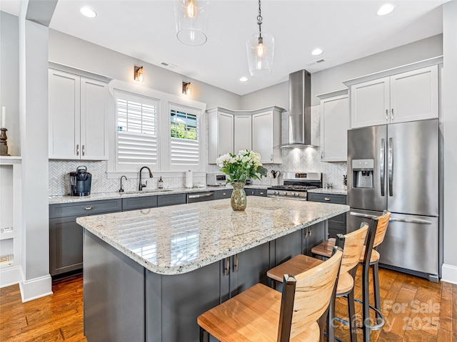 294 W Main St, Brevard, NC 28712 - kitchen with appliances with stainless steel finishes, wall chimney range hood, a center island, a kitchen bar, and tasteful backsplash
