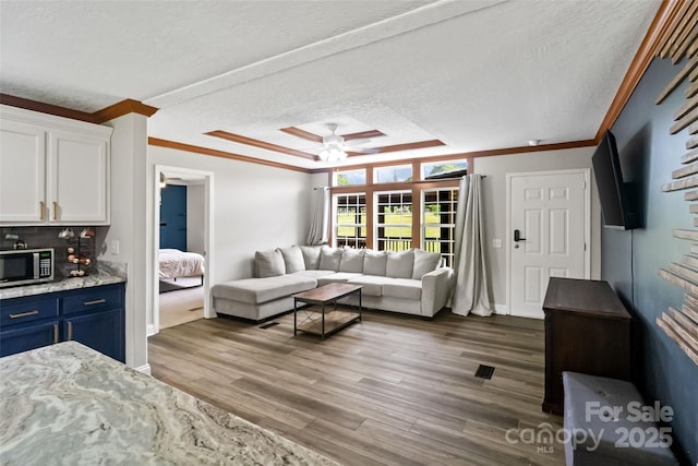 2021 Beamguard Rd, Clover, SC 29710 - living area with crown molding, a textured ceiling, a ceiling fan, wood finished floors, and baseboards