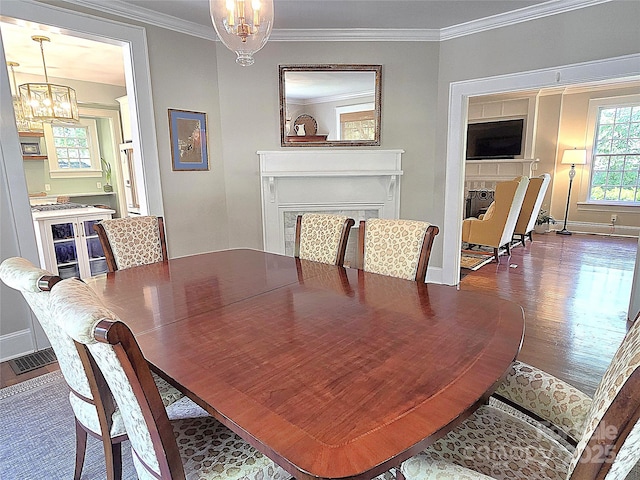 1051 14th Avenue Dr NW, Hickory, NC 28601 - dining room with a chandelier, wood finished floors, crown molding, baseboards, and a fireplace