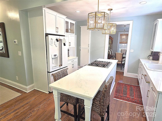 1051 14th Avenue Dr NW, Hickory, NC 28601 - kitchen with white refrigerator with ice dispenser, dark wood finished floors, a sink, a center island, and baseboards