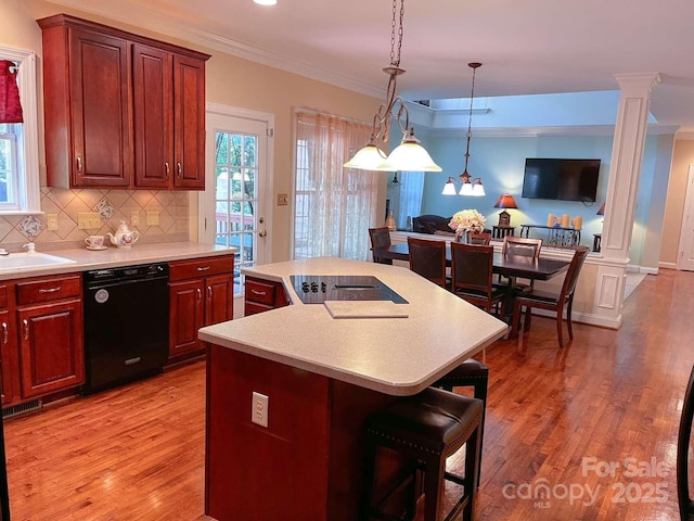 15494 Donnington Dr, Charlotte, NC 28277 - kitchen with black appliances, decorative columns, a breakfast bar, light countertops, and crown molding