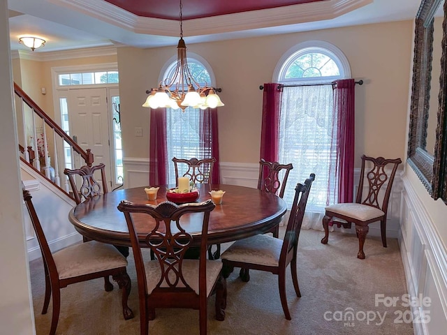 15494 Donnington Dr, Charlotte, NC 28277 - dining area featuring ornamental molding, a raised ceiling, light colored carpet, wainscoting, and stairs