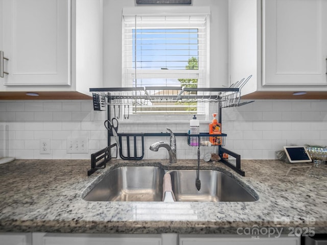 10426 Kempsford Dr, Charlotte, NC 28262 - kitchen view of a sink, white cabinetry, decorative backsplash, and light stone countertops