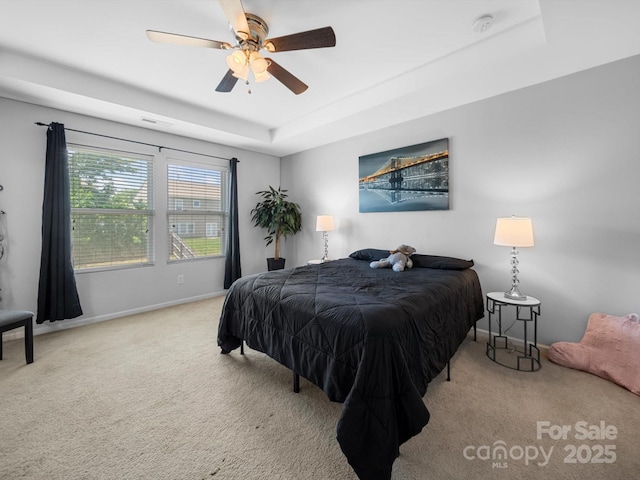 10426 Kempsford Dr, Charlotte, NC 28262 - carpeted bedroom featuring baseboards, a tray ceiling, and ceiling fan