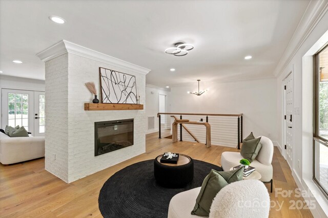 5033 Waxhaw Indian Trail Rd, Matthews, NC 28104 - living area with ornamental molding, light wood-style flooring, recessed lighting, a chandelier, and a brick fireplace