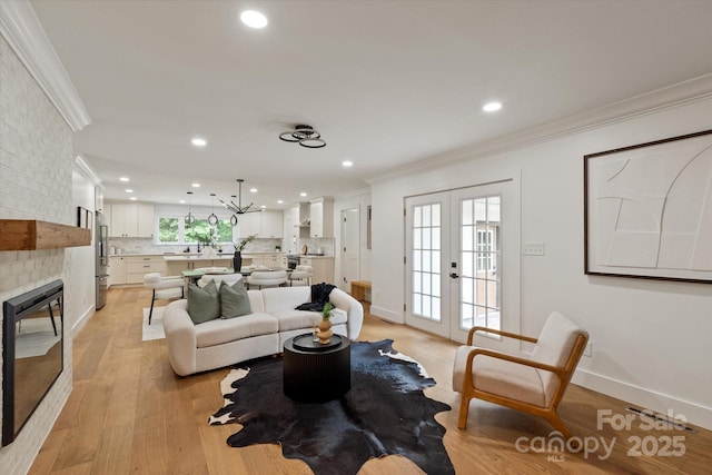 5033 Waxhaw Indian Trail Rd, Matthews, NC 28104 - living area with french doors, ornamental molding, recessed lighting, light wood-style flooring, and a fireplace