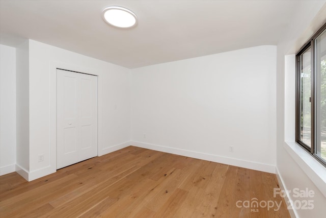 5033 Waxhaw Indian Trail Rd, Matthews, NC 28104 - unfurnished bedroom with light wood-style flooring, baseboards, and a closet