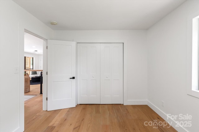 5033 Waxhaw Indian Trail Rd, Matthews, NC 28104 - unfurnished bedroom with light wood-style flooring, a closet, and baseboards