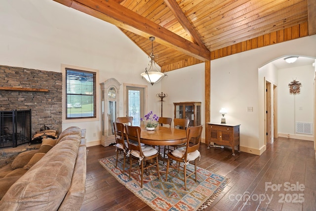 3540 Fork Creek Rd, Saluda, NC 28773 - dining space with arched walkways, dark wood-style flooring, a wooden ceiling with exposed beams, high vaulted ceiling, and a stone fireplace