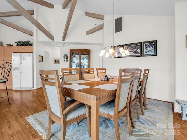 698 Youngs Mountain Dr, Lake Lure, NC 28746 - dining space with light wood-style flooring, beamed ceiling, a chandelier, baseboards, and high vaulted ceiling