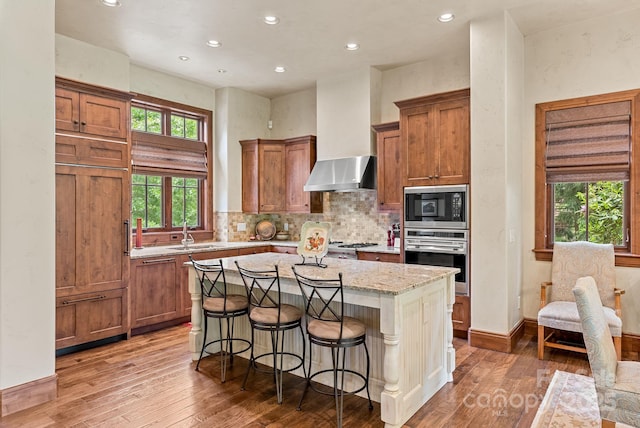 577 Walnut Valley Pkwy, Arden, NC 28704 - kitchen featuring oven, built in microwave, recessed lighting, hardwood / wood-style flooring, and brown cabinetry