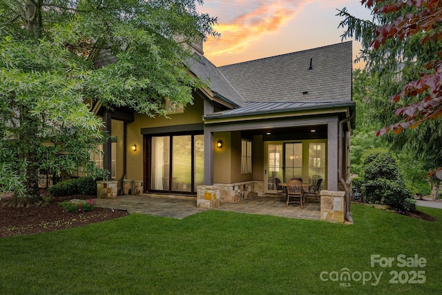 577 Walnut Valley Pkwy, Arden, NC 28704 - back of property at dusk featuring a standing seam roof, a patio area, a lawn, and metal roof