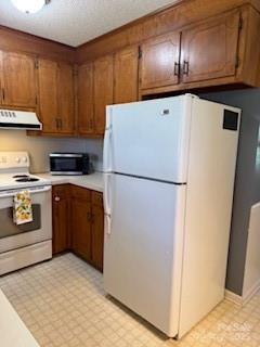 2669 Icard Rhodhiss Rd, Connelly Springs, NC 28612 - kitchen with white appliances, exhaust hood, light countertops, light floors, and brown cabinetry