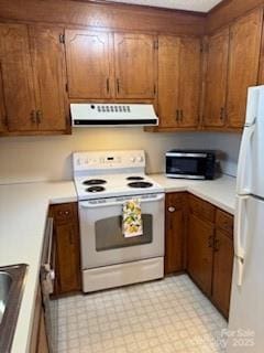 2669 Icard Rhodhiss Rd, Connelly Springs, NC 28612 - kitchen with white appliances, range hood, light countertops, brown cabinetry, and light floors