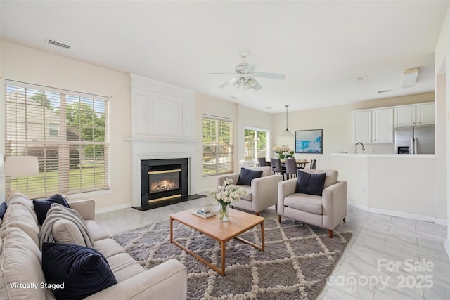 2013 Arbor Crest Ct, Charlotte, NC 28262 - living room featuring ceiling fan, a fireplace with flush hearth, baseboards, and light marble finish floors