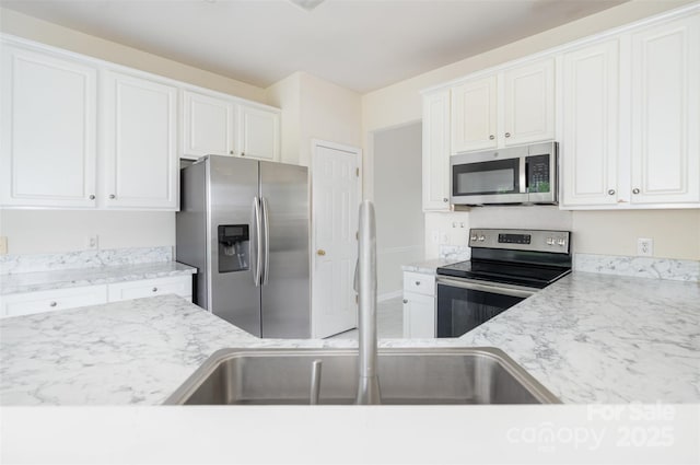 2013 Arbor Crest Ct, Charlotte, NC 28262 - kitchen featuring stainless steel appliances, white cabinetry, a sink, baseboards, and light stone countertops