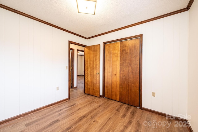 3020 Doc Pugh Rd, Connelly Springs, NC 28612 - unfurnished bedroom featuring wood finished floors, a textured ceiling, a closet, crown molding, and baseboards