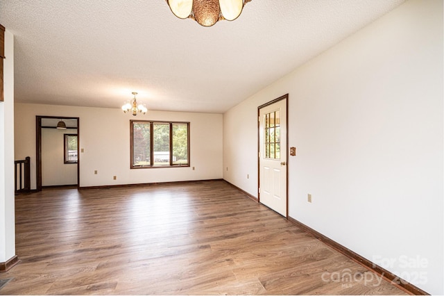 3020 Doc Pugh Rd, Connelly Springs, NC 28612 - unfurnished room with a chandelier, light wood-style flooring, and baseboards