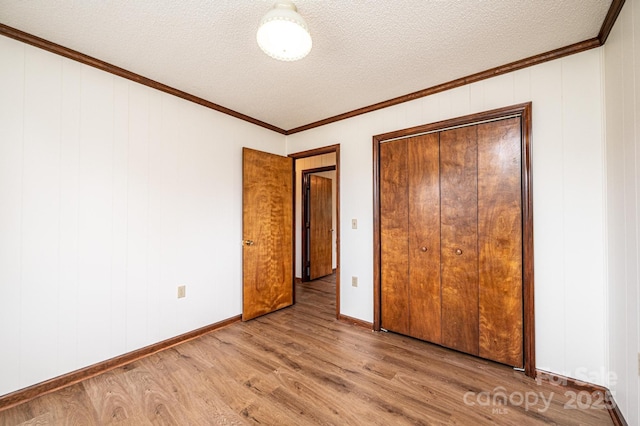 3020 Doc Pugh Rd, Connelly Springs, NC 28612 - unfurnished bedroom with wood finished floors, ornamental molding, a textured ceiling, baseboards, and a closet