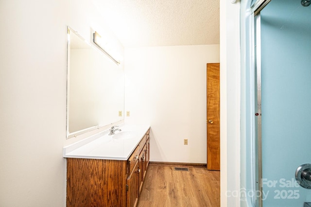 3020 Doc Pugh Rd, Connelly Springs, NC 28612 - bathroom featuring wood finished floors, vanity, a textured ceiling, and baseboards