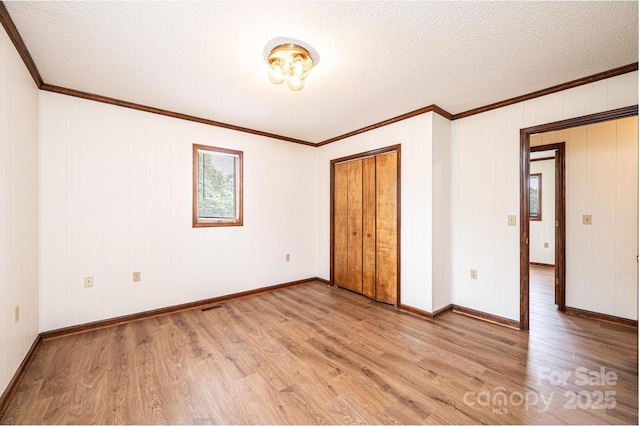 3020 Doc Pugh Rd, Connelly Springs, NC 28612 - unfurnished bedroom with wood finished floors, a textured ceiling, crown molding, baseboards, and a closet