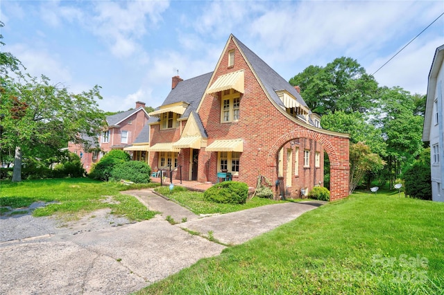 611 E Marion St, Shelby, NC 28150 - english style home with a front lawn, a chimney, brick siding, and a shingled roof