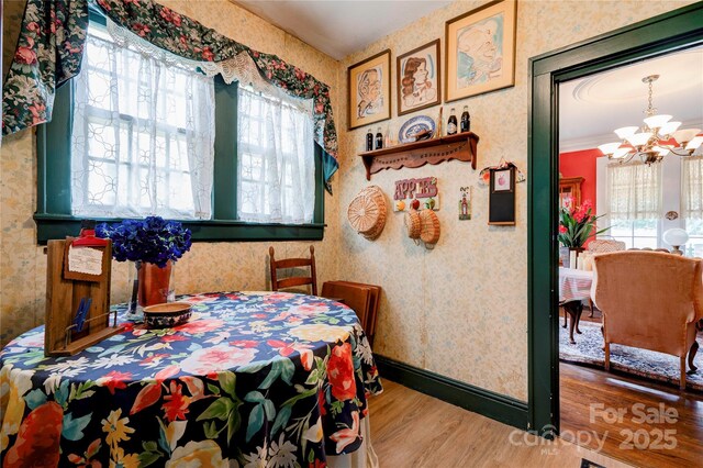 611 E Marion St, Shelby, NC 28150 - dining area featuring wallpapered walls, a chandelier, wood finished floors, and baseboards