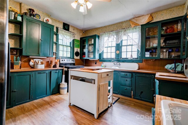 611 E Marion St, Shelby, NC 28150 - kitchen featuring green cabinets, open shelves, healthy amount of natural light, light wood-type flooring, and wallpapered walls