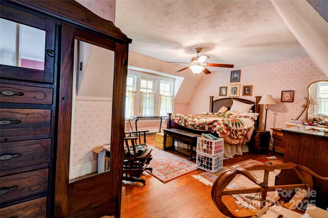 611 E Marion St, Shelby, NC 28150 - bedroom with wallpapered walls, wood finished floors, lofted ceiling, and a textured ceiling