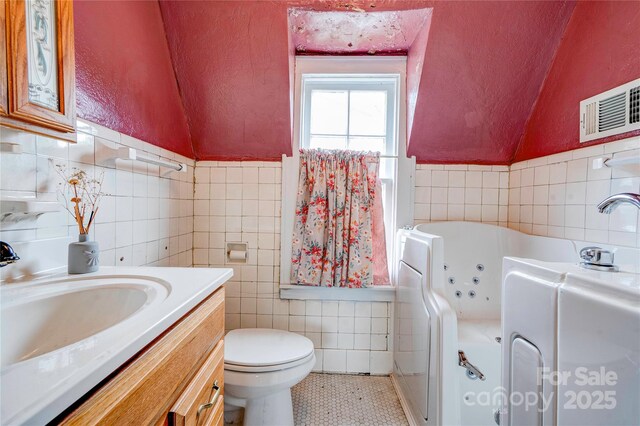 611 E Marion St, Shelby, NC 28150 - full bathroom with tile walls, tile patterned flooring, a whirlpool tub, vanity, and toilet