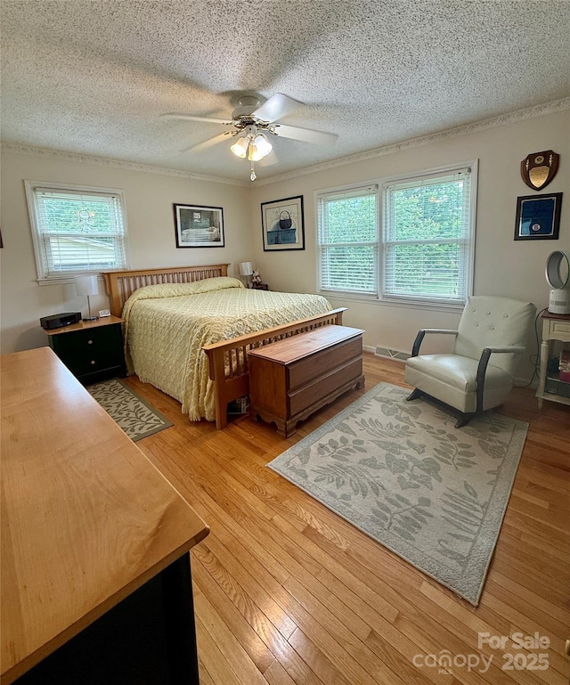 403 Kings Dr, Cherryville, NC 28021 - bedroom with a textured ceiling, light wood-style flooring, multiple windows, a ceiling fan, and ornamental molding
