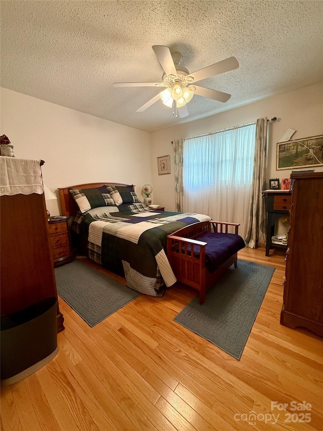 403 Kings Dr, Cherryville, NC 28021 - bedroom featuring a textured ceiling, light wood-style flooring, and ceiling fan